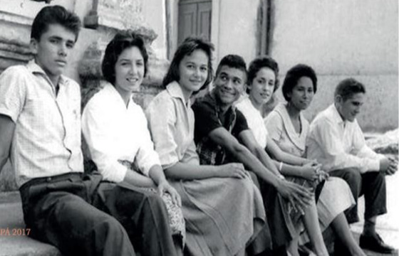 Foto em preto e branco de pessoas sentadas

Descrição gerada automaticamente